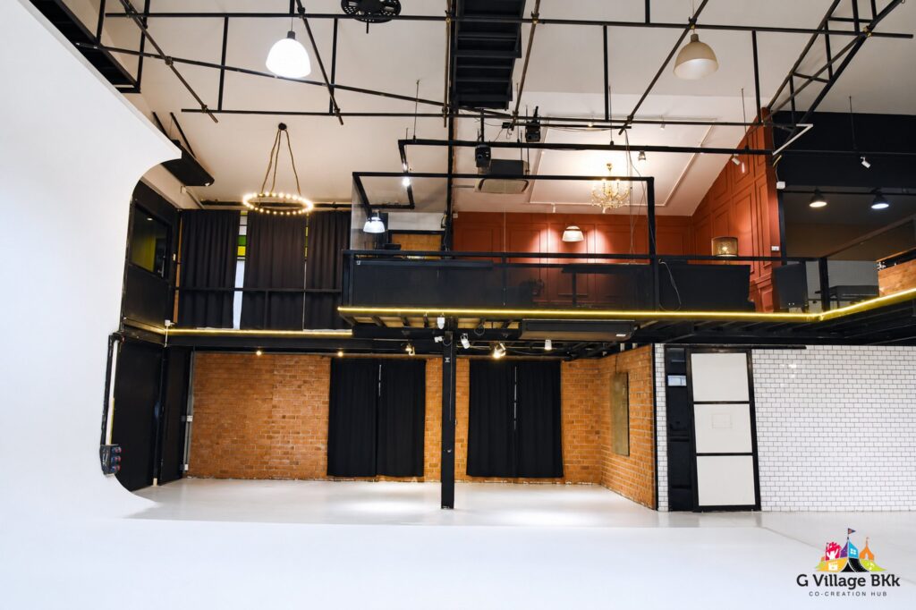 พื้นที่ชั้น 1 ของ The Circus Studio มองไปยังผนังอิฐและระเบียงชั้นบน