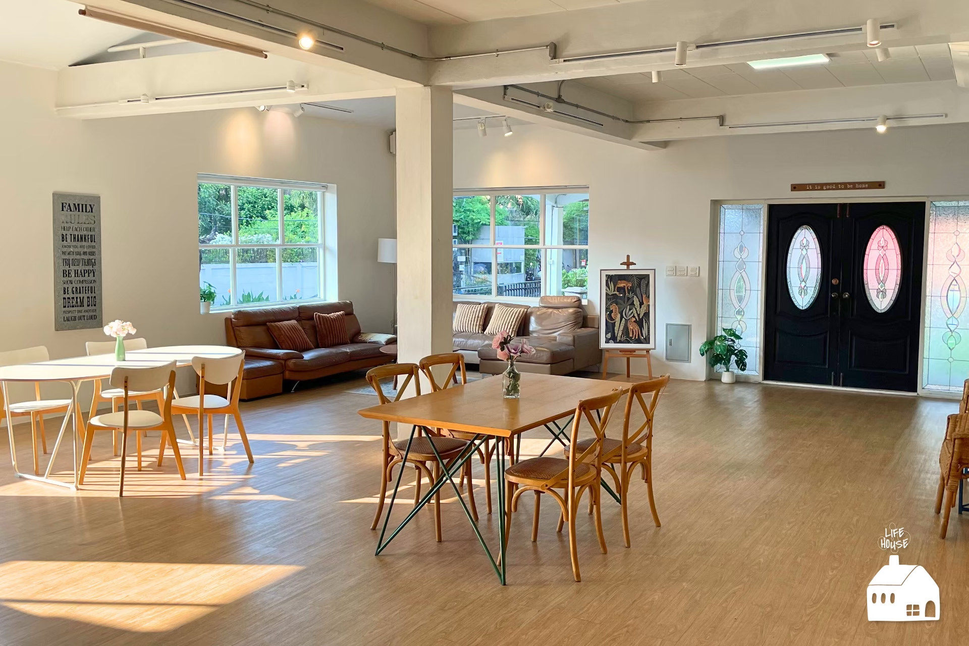 LIVING ROOM ห้องนั่งเล่นกว้าง มีโต๊ะ เก้าอี้ และโซฟา รับแสงจากหน้าต่างใน Life House Studio