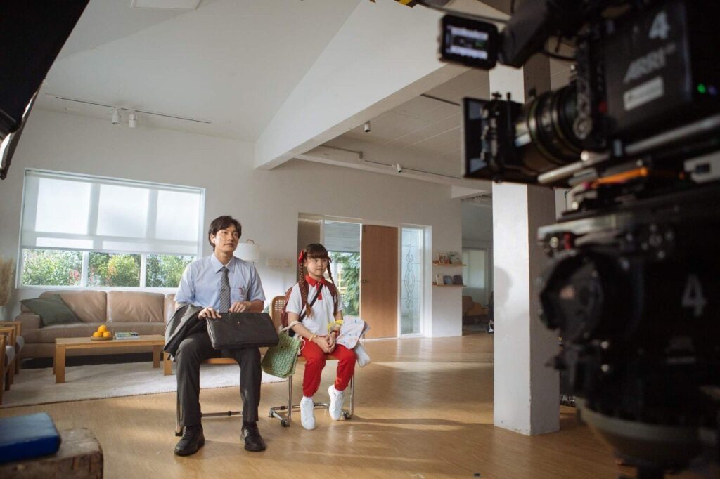 ทีมถ่ายทำและผู้ร่วมฉากบริเวณโซฟาในห้องนั่งเล่น